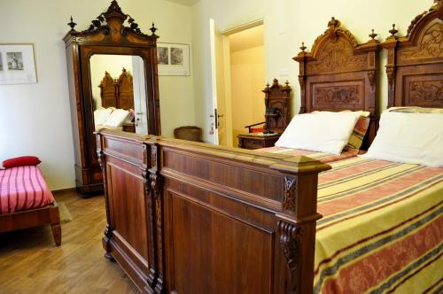 a bedroom with a large wooden bed and a large mirror at Le Macine Relais in Cairo Montenotte