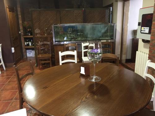a wooden table with a wine glass on top of it at Hotel Marfrei in Hinojedo