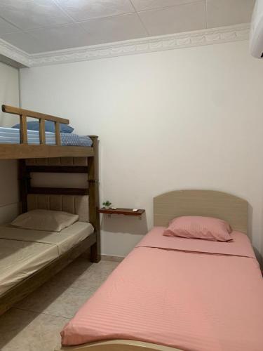 a bedroom with two bunk beds and a pink blanket at La casa de Fefa in Ríohacha
