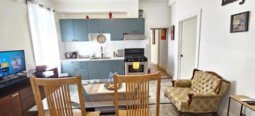 a kitchen with a table and two chairs and a kitchen with blue cabinets at Great Location -Mural, Barn and Corridor -1 Bed 1Bath Apartments! in Windsor