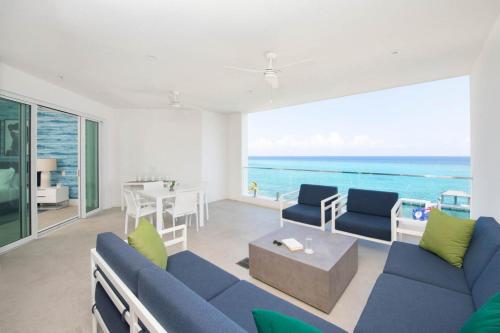 salon z niebieską kanapą i widokiem na ocean w obiekcie Rum Point Resort 404 w mieście Driftwood Village