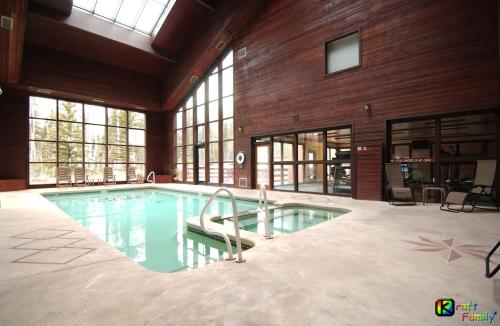 a large swimming pool in a large room with windows at Royal Vista III Pool-Spa Ski-in out Gym, Sauna, Laundry, BBQ in Brian Head
