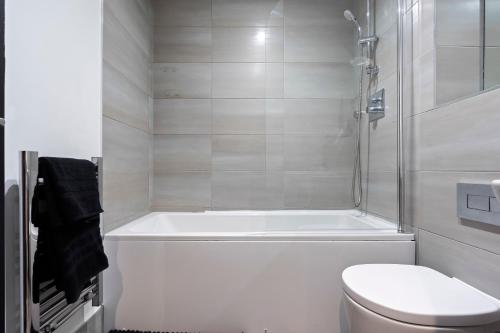バーミンガムにあるBelgravia Quarters Ltdの浴槽、トイレ、シャワー付きのバスルーム