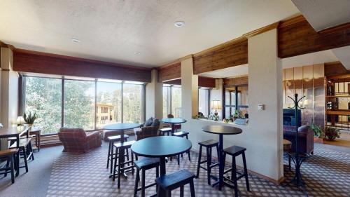 a room with tables and chairs in a room withwindows at Royal Vista III Pool-Spa Ski-in out Gym, Sauna, Laundry, BBQ in Brian Head
