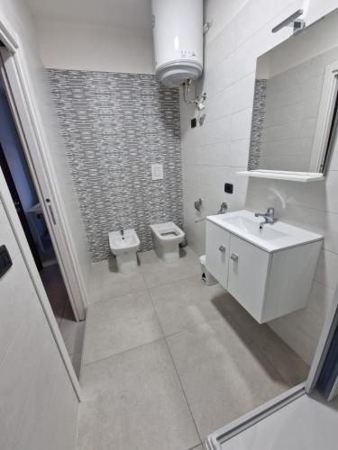 a white bathroom with a sink and a toilet at Casa Alba Napoli in Naples