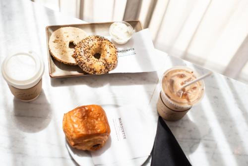 a table with a plate of donuts and two drinks at The Marquette Hotel, Curio Collection by Hilton in Minneapolis