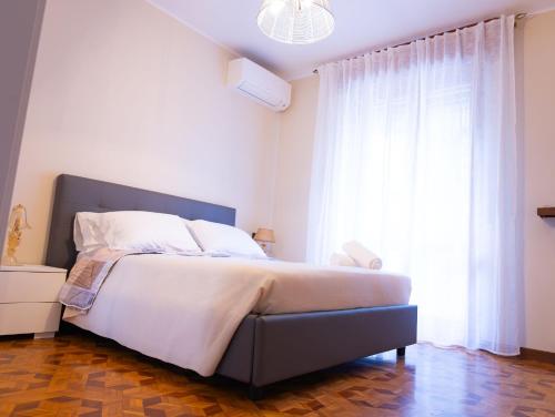 a bedroom with a bed and a large window at Civico 5 in Piacenza