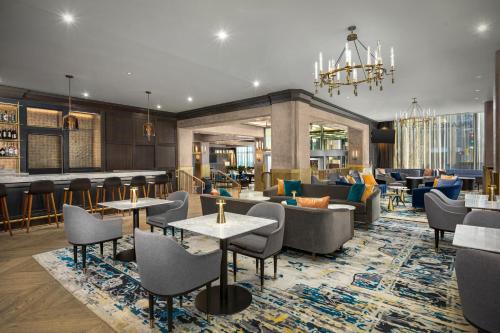a hotel lobby with tables and chairs and a bar at The Marquette Hotel, Curio Collection by Hilton in Minneapolis