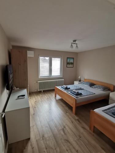 a room with two beds and a television in it at Apartman Meridian in Zaječar