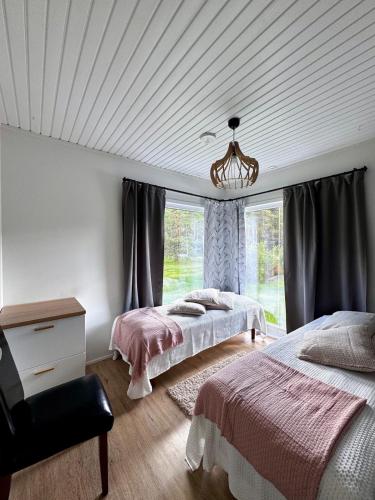 a bedroom with two beds and a chandelier at Villa Ketola in Ranua