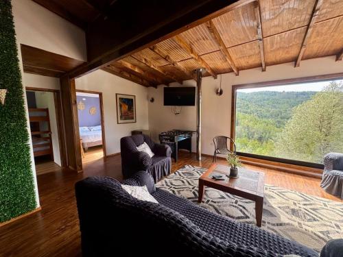 a living room with two couches and a table at Casa con vista al rio Cutipay in Niebla