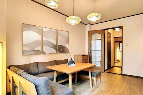 uma sala de estar com um sofá e uma mesa em Luna Luxury 4BR Family Villa with Parking - 2 mins from Osaka-ko Station, near EXPO, USJ, Kaiyukan em Osaka