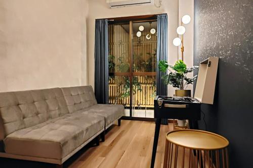 uma sala de estar com um sofá e uma mesa em Luna Luxury 4BR Family Villa with Parking - 2 mins from Osaka-ko Station, near EXPO, USJ, Kaiyukan em Osaka