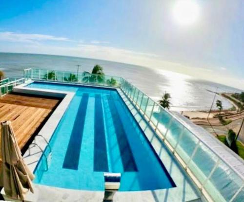 una piscina vicino alla spiaggia e all'oceano di Flat JP Beira mar a João Pessoa