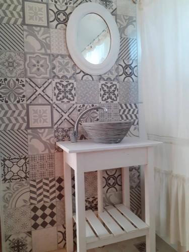 Un baño con un lavabo y un espejo en la pared. en Tu casita en sierras, en Sierra de los Padres