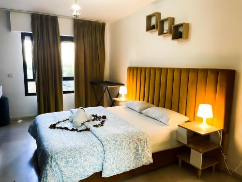 a bedroom with a bed with a flower arrangement on it at Cozy equipped apartment near train station facing Hilton luxury comfort in Tangier