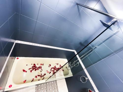 a mirror in a bathroom with red debris on the tub at Cozy equipped apartment near train station facing Hilton luxury comfort in Tangier