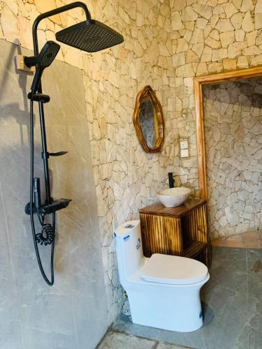 ein Badezimmer mit Dusche, Toilette und Waschbecken in der Unterkunft Kitabi EcoCenter in Kitabi