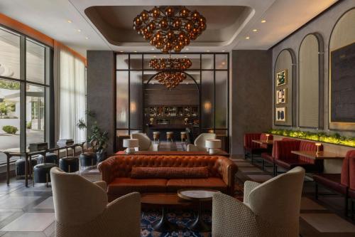 a lobby with a couch and tables and chairs at The Tess, Autograph Collection in Atlanta