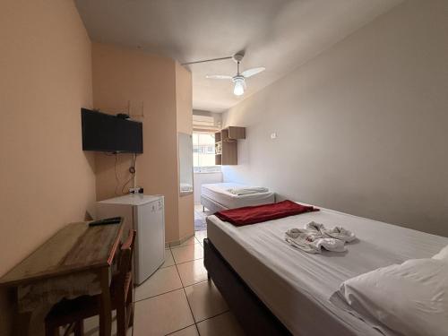 a small room with a bed and a small kitchen at Hotel Izaura Centro Comercial Juruaia in Juruaia