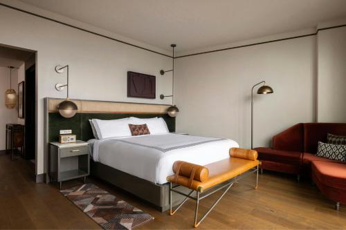 Un dormitorio con una cama, una silla y un sofá. en The Tess, Autograph Collection, en Atlanta