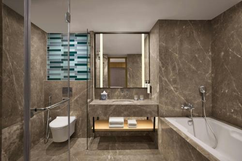 a bathroom with a tub and a sink and a toilet at Fairfield by Marriott Mumbai Andheri West in Mumbai