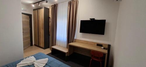 a bedroom with a bed and a television on a wall at Sremski Kutak in Stara Pazova