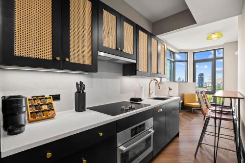 a kitchen with black cabinets and a counter top at Freeman II by Rove 1BR Condo with Shared Amenities in New York