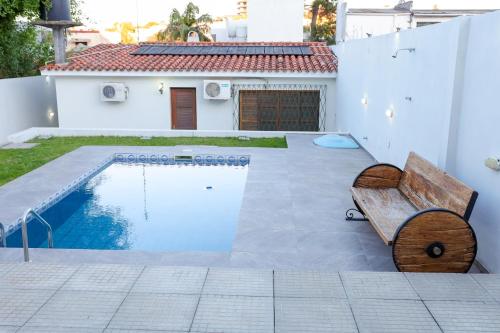 una panchina di legno seduta accanto alla piscina di Elegant House with Party Room a Santana do Livramento