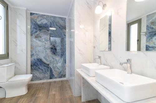 a white bathroom with two sinks and a toilet at NOPI HOLIDAYS Zante Exclusive Villa in Zakynthos Town