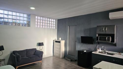 a living room with a couch and a sink at Loft con cocineta en colonia privada in Monterrey
