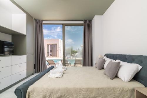 a bedroom with a large bed with a large window at NOPI HOLIDAYS Zante Exclusive Villa in Zakynthos Town
