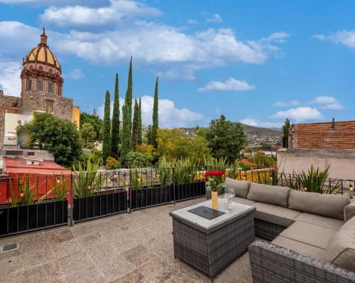 a rooftop patio with a couch and a table at Casa Yuca Hotel in San Miguel de Allende