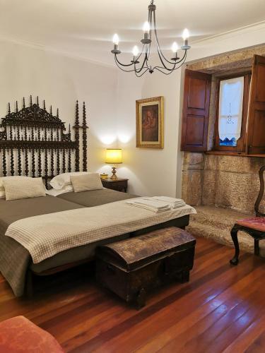 a bedroom with a large bed and a chandelier at Casa do Faial - Braga in Braga