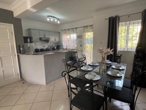 a kitchen and dining room with a table and chairs at Charming Apartment with Pool View Near the Beach in Flic-en-Flac