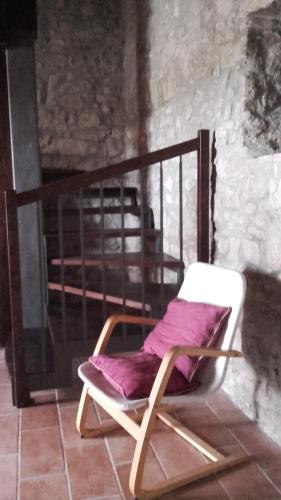 a wooden chair sitting in front of a fireplace at Country Relais La Torretta Baronale in San Giorgio Montagna
