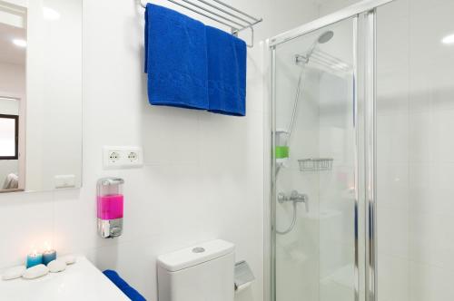 a white bathroom with a shower and a toilet at Hotel Apartamento Bajamar in Las Palmas de Gran Canaria