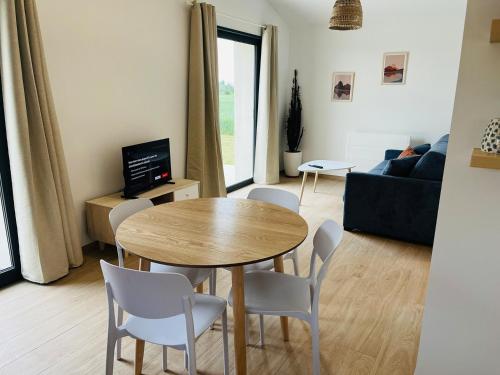 a living room with a table and chairs and a couch at Maison proche de la Gare TGV in Alixan