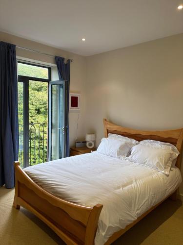 a bedroom with a large bed and a window at The Mill Sixmilewater Mill Antrim in Antrim