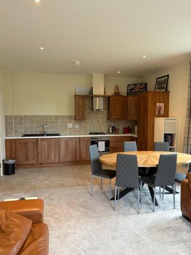 a large kitchen with a wooden table and chairs at The Mill Sixmilewater Mill Antrim in Antrim