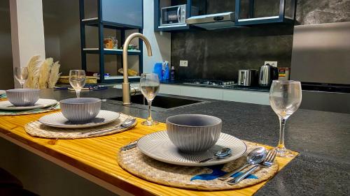 a kitchen with a table with plates and wine glasses at Serenity, Peace, Fulfilment all at one place in Pointe aux Piments