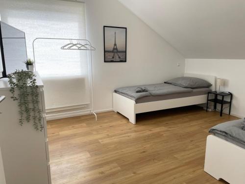a bedroom with two beds and a wooden floor at 2 bedroom apartment with 4 beds in Pfaffenhofen PAF01 in Pfaffenhofen