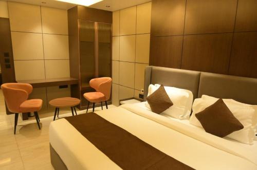 a hotel room with a bed and two chairs at Diesel inn hotel in Hanumāngarh