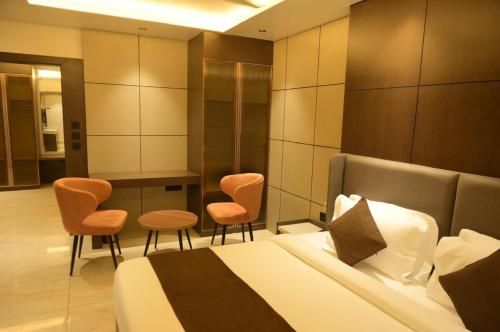 a bedroom with a bed and two chairs and a table at Diesel inn hotel in Hanumāngarh