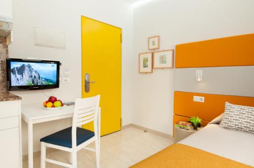 a room with a bed and a desk and a tv at Hotel Apartamento Bajamar in Las Palmas de Gran Canaria