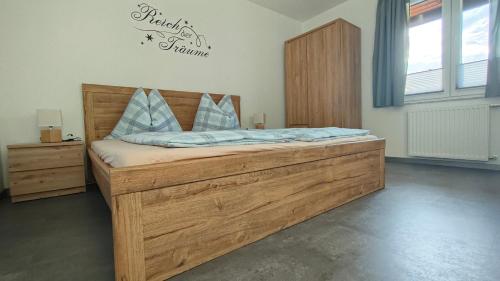 a bedroom with a wooden bed with blue pillows at Appartment Herzblick in Sankt Georgen im Gailtal