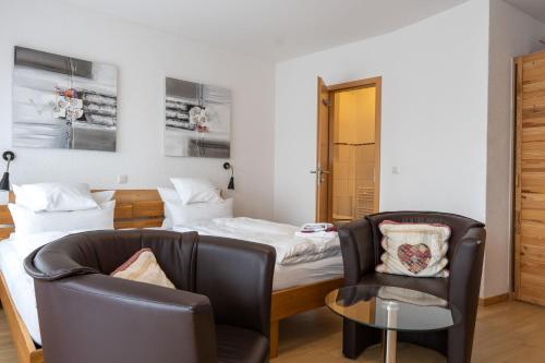 1 dormitorio con 2 camas, 2 sillas y mesa en WerkLoft Neckarsulm, en Neckarsulm