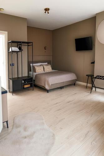 a bedroom with a bed and a flat screen tv at Manor Suite Amsterdam in Amsterdam