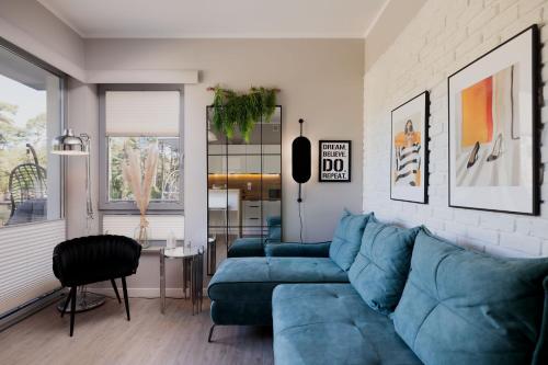 a living room with a blue couch and a table at Baltic 4YOU in Pobierowo