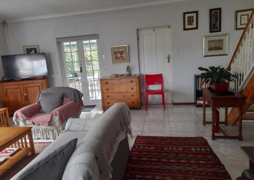 a living room with a couch and a tv at Jaco and Liz's sea get away in Hermanus